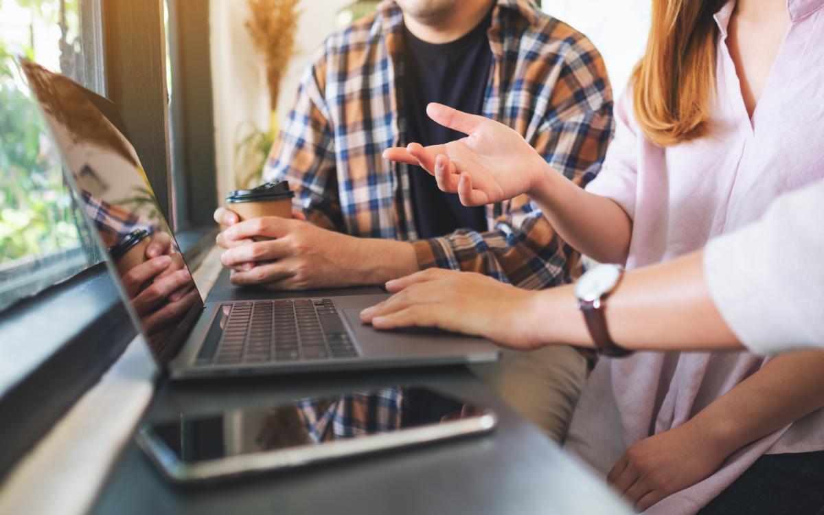 Csapat tartalomstratégián dolgozik laptop mellett egy kávézóban